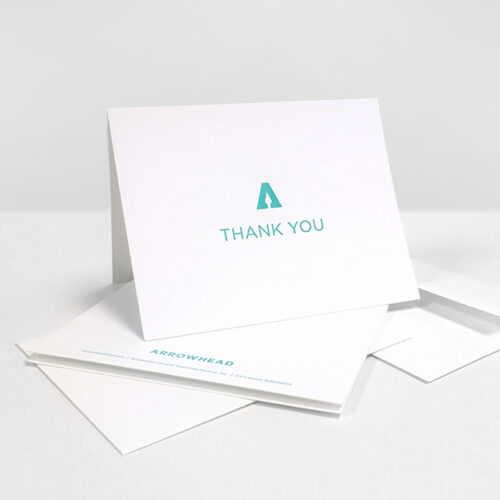 White folded thank you card with green Arrowhead logo and Thank You
